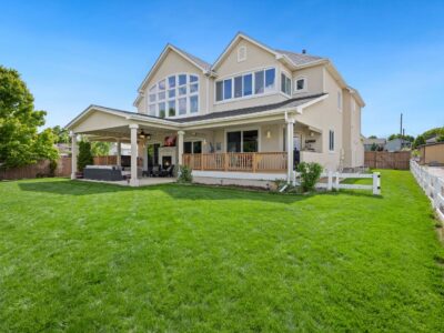 manicured residential backyard lawn, house and fence in frame