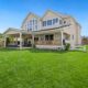 manicured residential backyard lawn, house and fence in frame